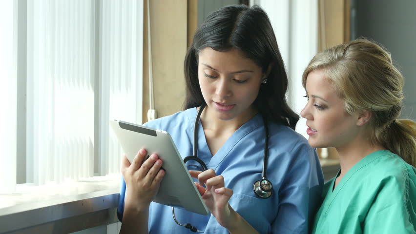 Nurses using a tablet to report a near miss event in healthcare